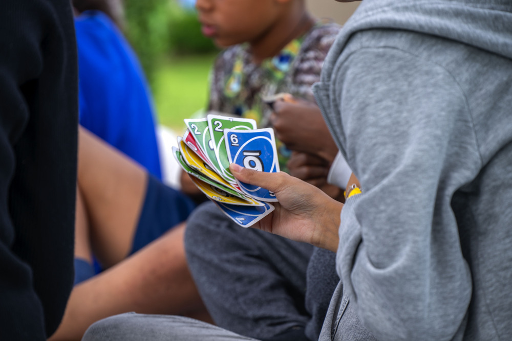 Ett barns hand som håller i färgglada kort